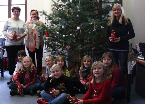 Hortleiterin Evelyn Clare, Bürgermeisterin Regina Blenkle und Hortnerin Marion Bortfeldt (v.li.) mit den Kindern: Lorelei, Maya, Johanna, Pauline, Nora, Charlotte, Elina, Chantale (v.li.) vor der geschmückten Tanne