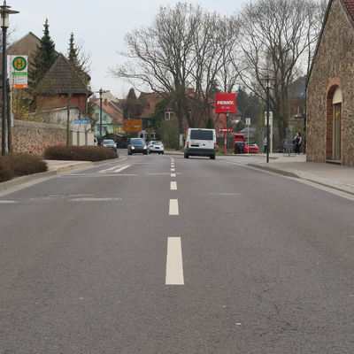 Die Neuhaldensleber Stra&szlig;e in Olln zwischen Kreisel und Gro&szlig;e Str. - Bushaltestellen und mehrere Einfahrten erlauben leider nicht das Anlegen eines Fu&szlig;g&auml;nger&uuml;berweges
