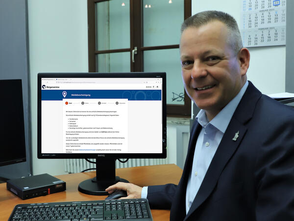 Bürgermeister Bernhard Hieber in seinem Büro. Auf seinem Bildschirm: die Startseite für die Beantragung einer Meldebescheinigung
